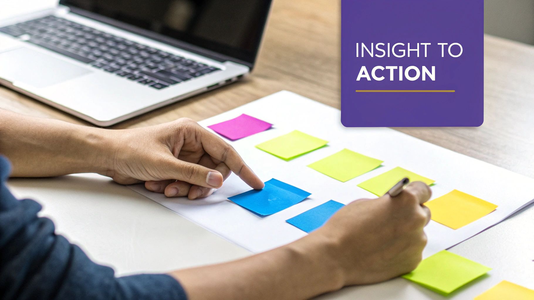 Hands arranging colorful sticky notes on a paper, with a laptop in the background and 'Insight to Action' text.