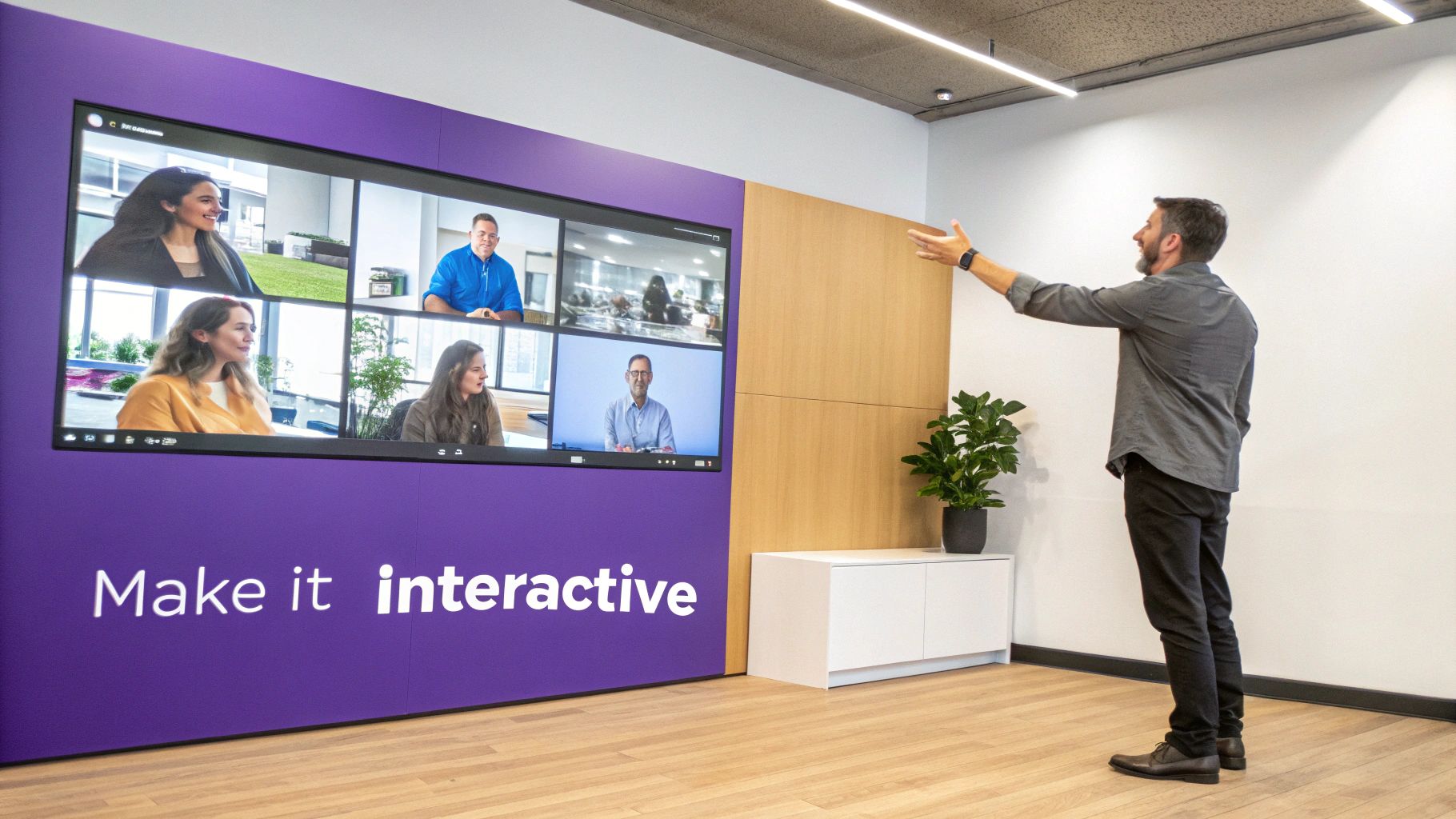 Man in a modern office gestures towards a large interactive display showing a video conference.