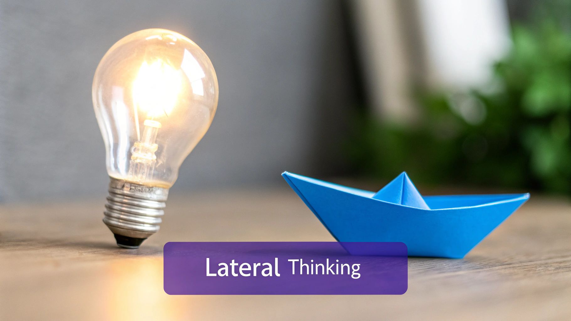 A glowing light bulb and a blue paper boat on a wooden table, with 'Lateral Thinking' text.