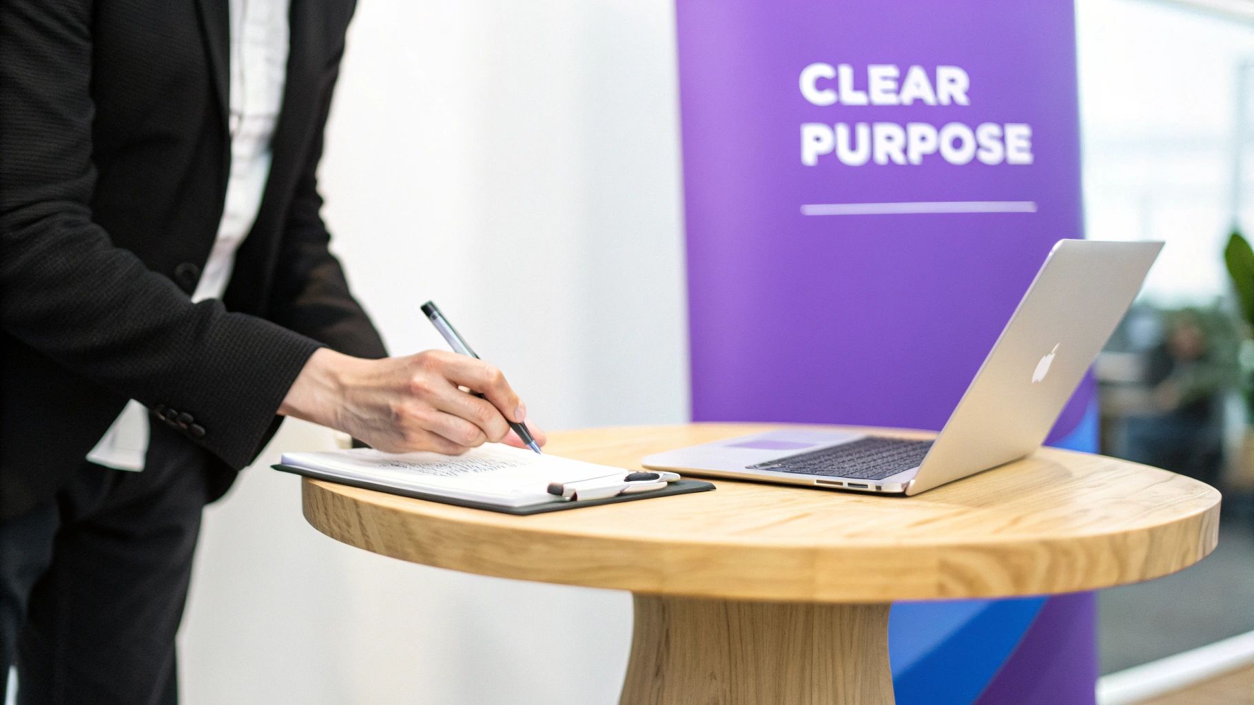 Professional writing on a clipboard next to a laptop, with a 'Clear Purpose' banner.