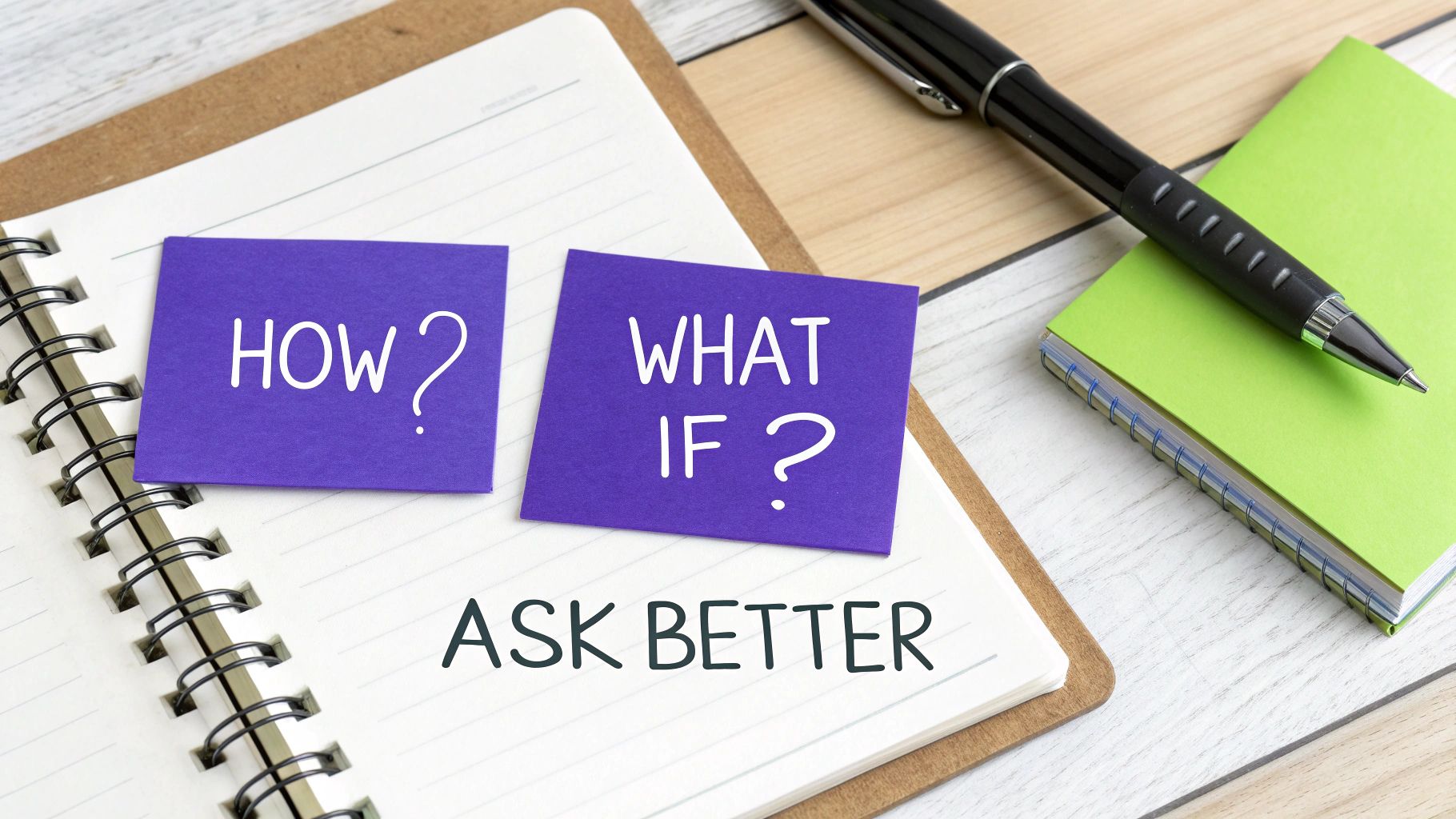 An open notebook with sticky notes asking 'HOW?' and 'WHAT IF?' above the text 'ASK BETTER'.