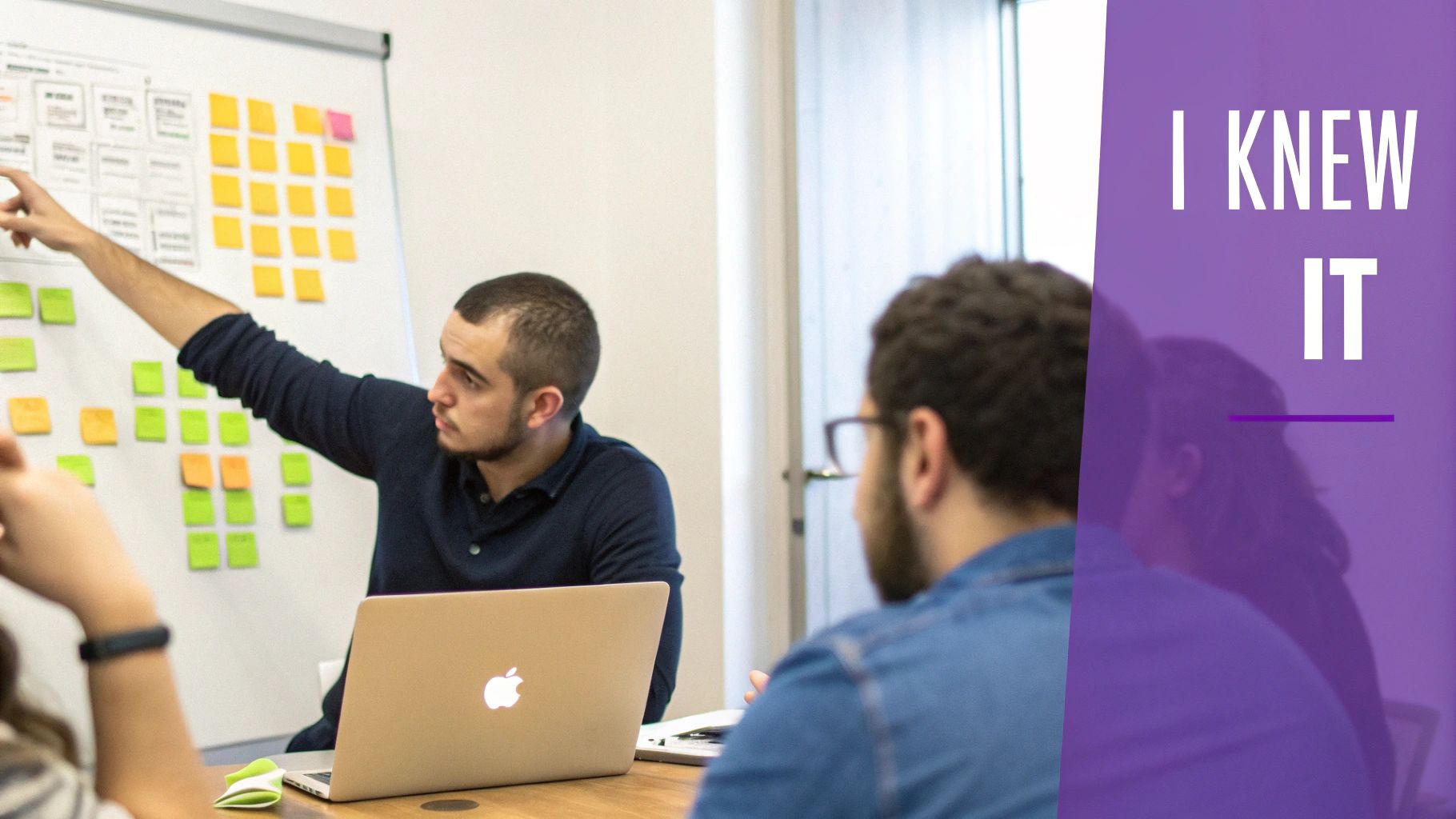 A man points at sticky notes on a whiteboard during a collaborative meeting, explaining ideas.