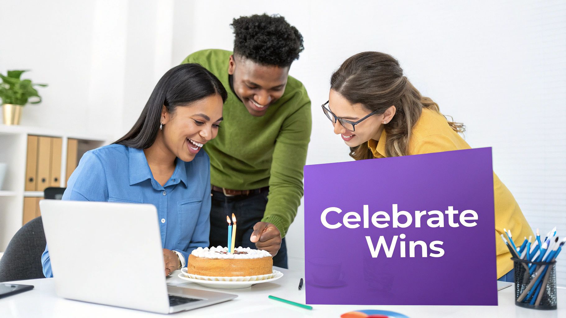 Three diverse colleagues smiling, celebrating a team win or birthday with cake and a "Celebrate Wins" sign.