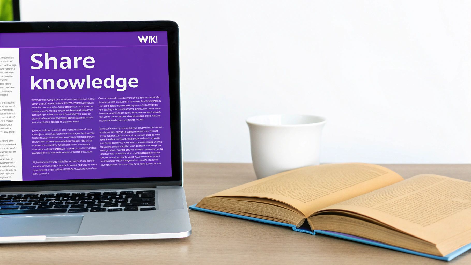 A laptop displaying 'Share knowledge WIKI' next to an open book and a white cup on a desk.