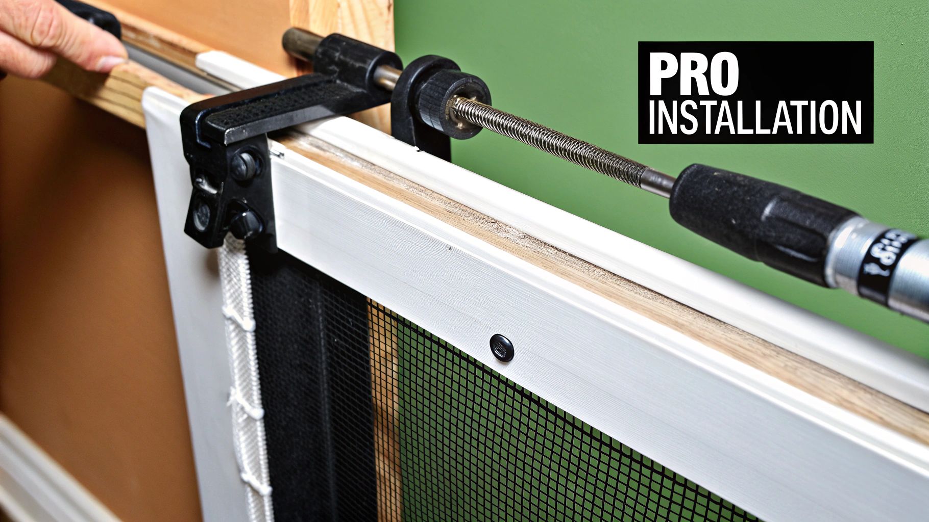 A person using a spline roller tool to install a new screen into a door frame laid flat on a work surface.