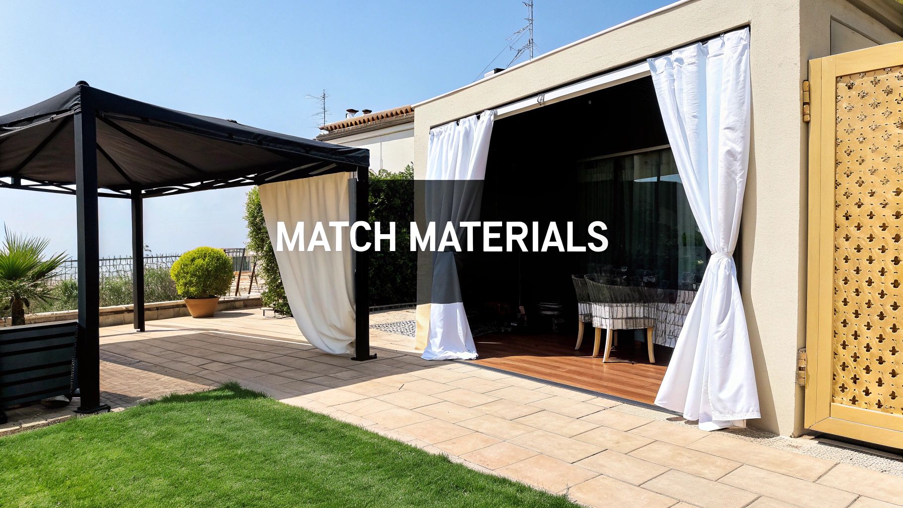 Outdoor living space featuring a black pergola, white curtains, and a tiled patio with green grass.