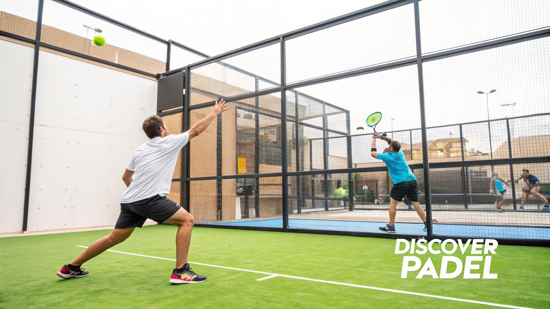 A group of four people playing paddle tennis on an enclosed court with glass walls.