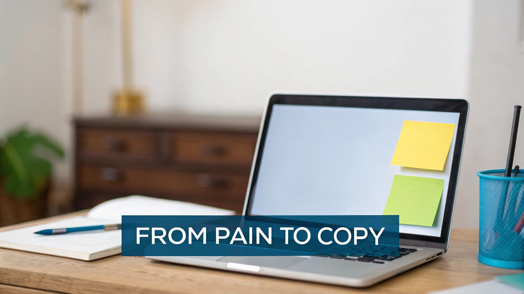 Laptop with sticky notes on its screen, a notebook, and pens on a wooden desk, with text 'FROM PAIN TO COPY'.