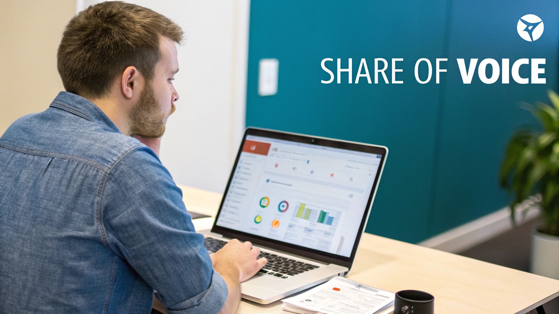 A man analyzing marketing data on a laptop, with 'SHARE OF "VOICE' text on a teal wall.
