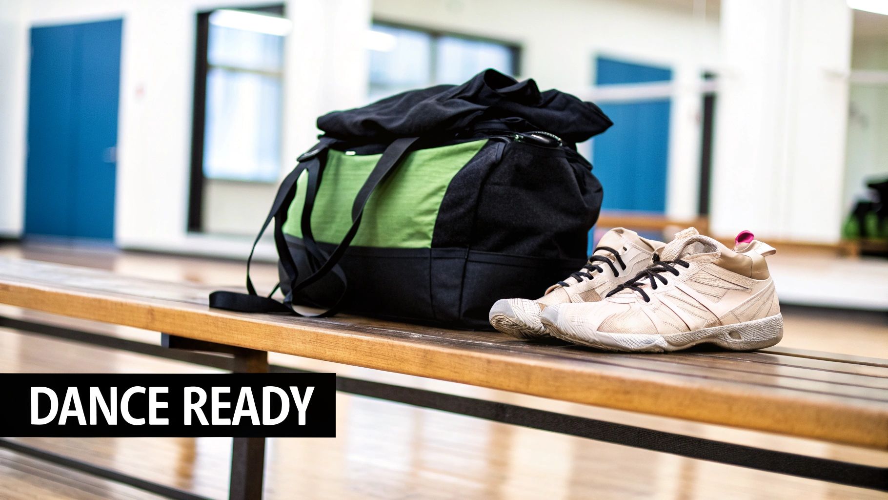 A green and black duffel bag and beige dance shoes are on a wooden bench, ready for a dance class.