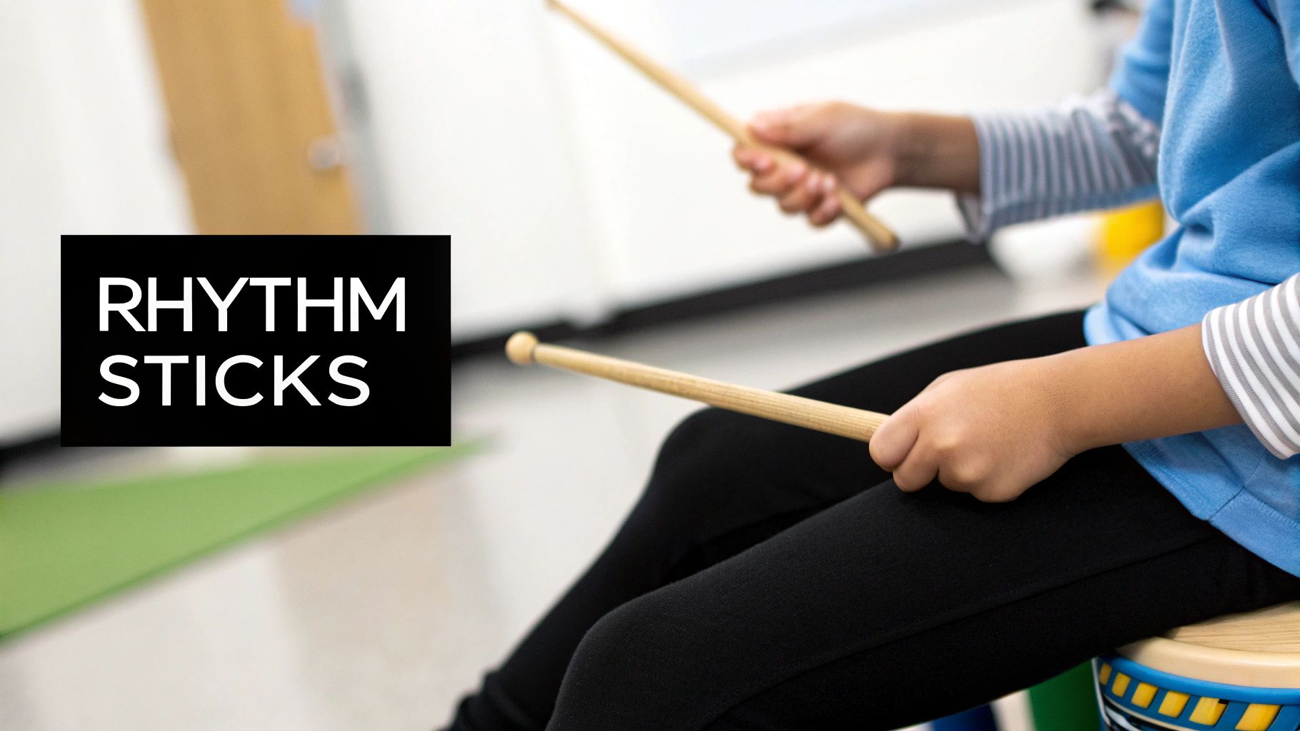 A child in a blue shirt holds rhythm sticks, participating in a music activity.