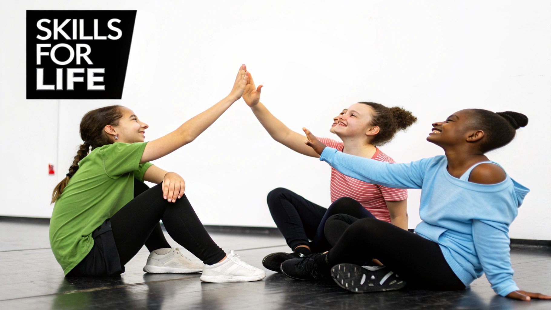 Three diverse young girls happily high-fiving on the floor, embodying teamwork and joy.