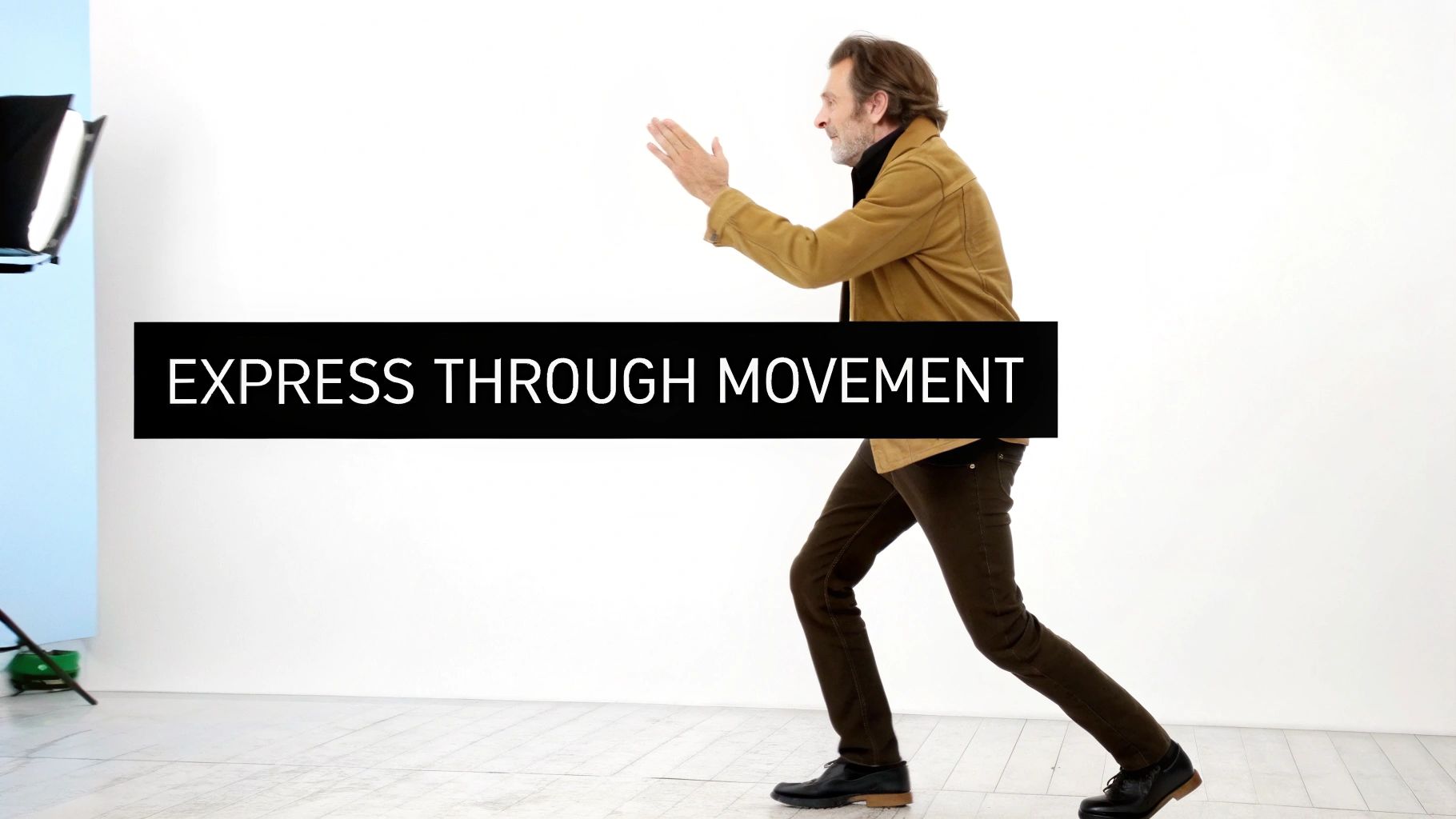 A man in a studio practices expressive physical movement, with text "EXPRESS THROUGH MOVEMENT".