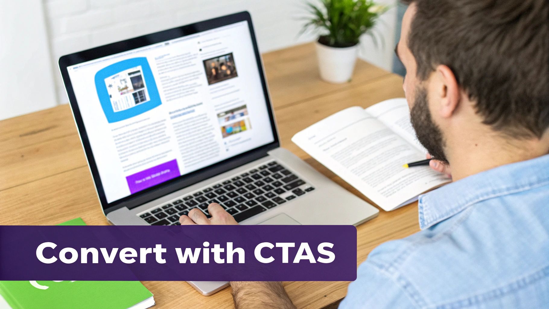 A person works on a laptop showing a website with CTAs, while also reading a book.