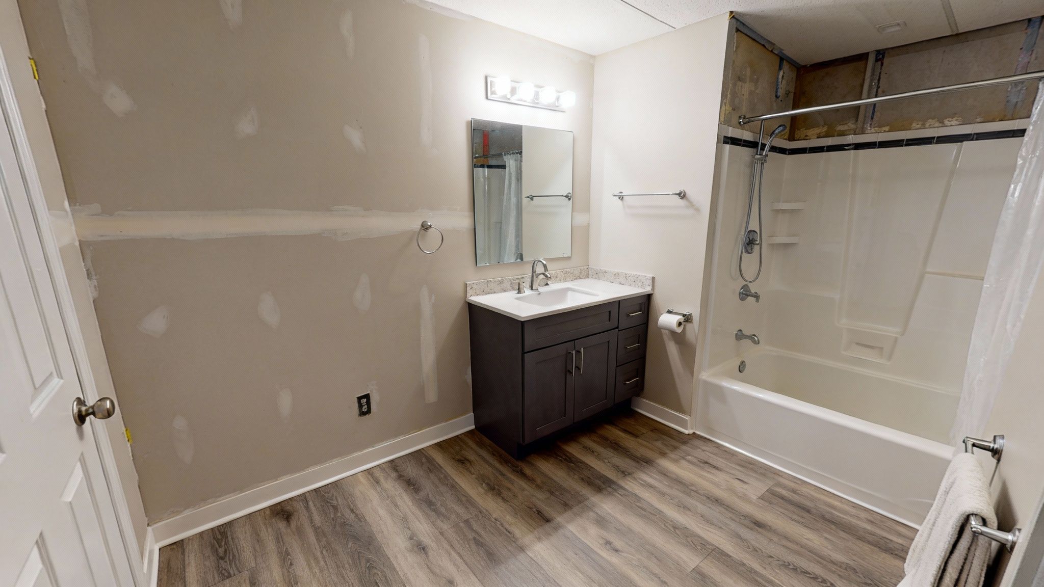 A newly finished modern basement bathroom with bright lighting and a glass shower door.