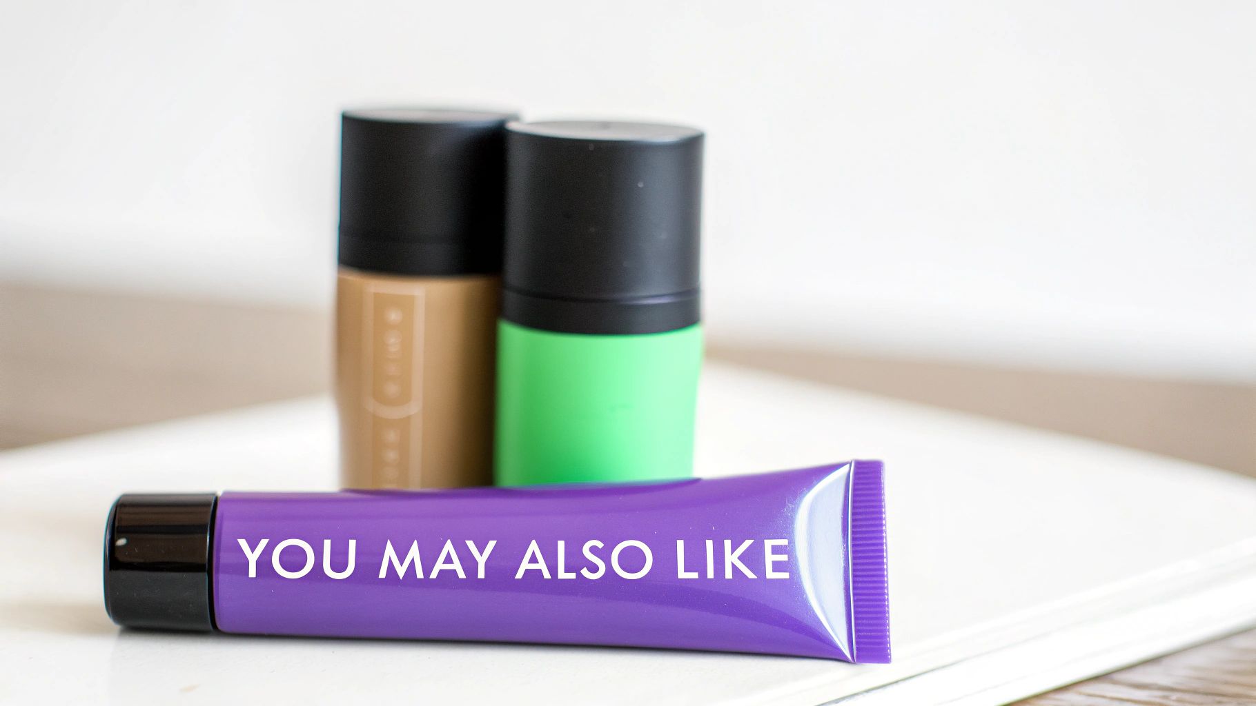 A purple tube labeled 'YOU MAY ALSO LIKE' with two blurred cosmetic bottles in the background.