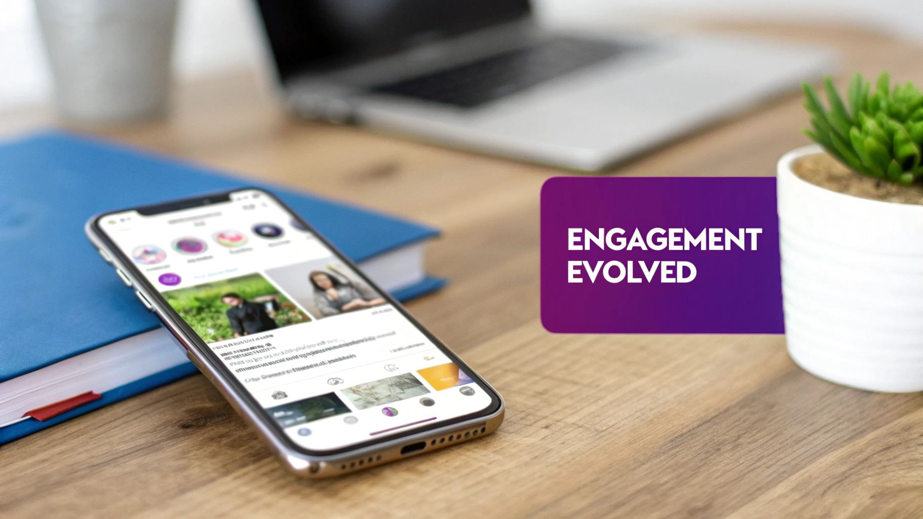 Desk setup with a smartphone displaying social media, a blue book, laptop, and plant, featuring 'ENGAGEMENT EVOLVED' text.