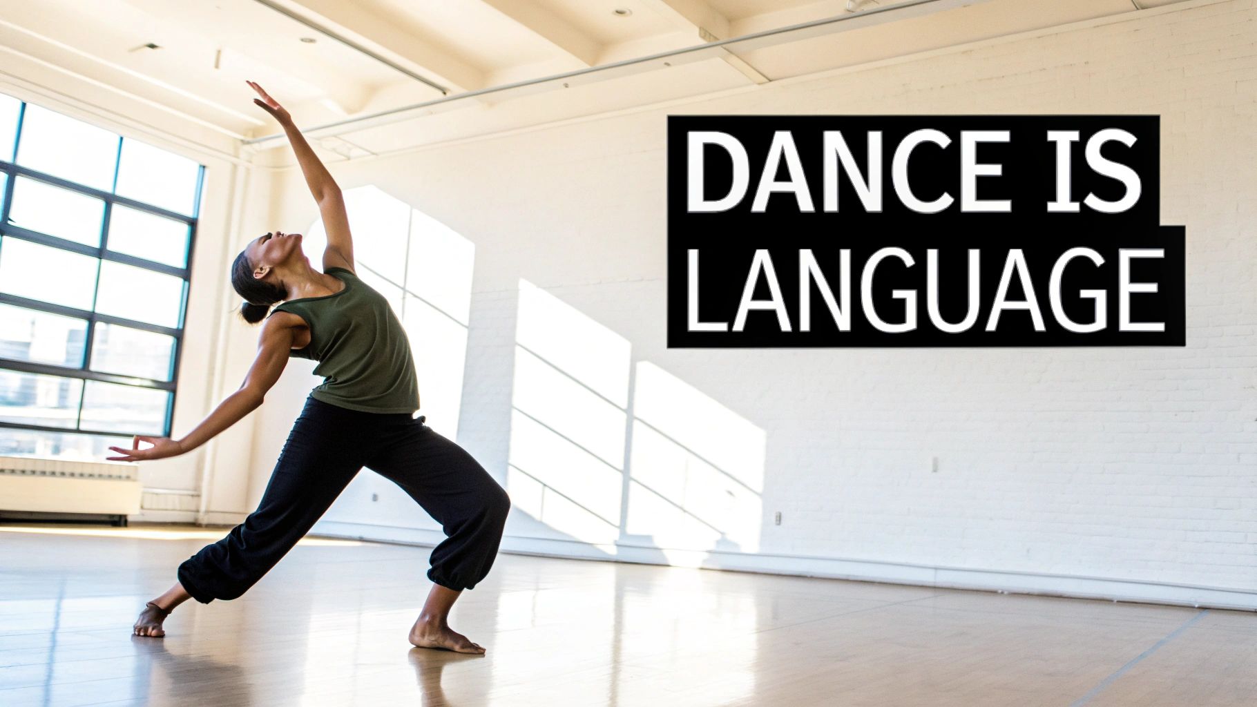A female dancer in a studio, reaching upwards, with text 'DANCE IS LANGUAGE' on the wall.