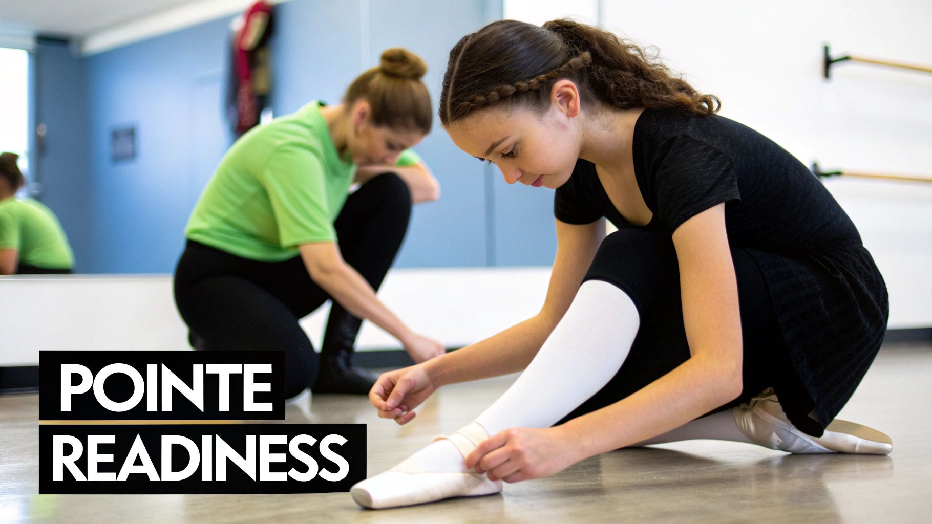 A young girl ties her pointe ballet shoes, demonstrating readiness in a bright dance studio.