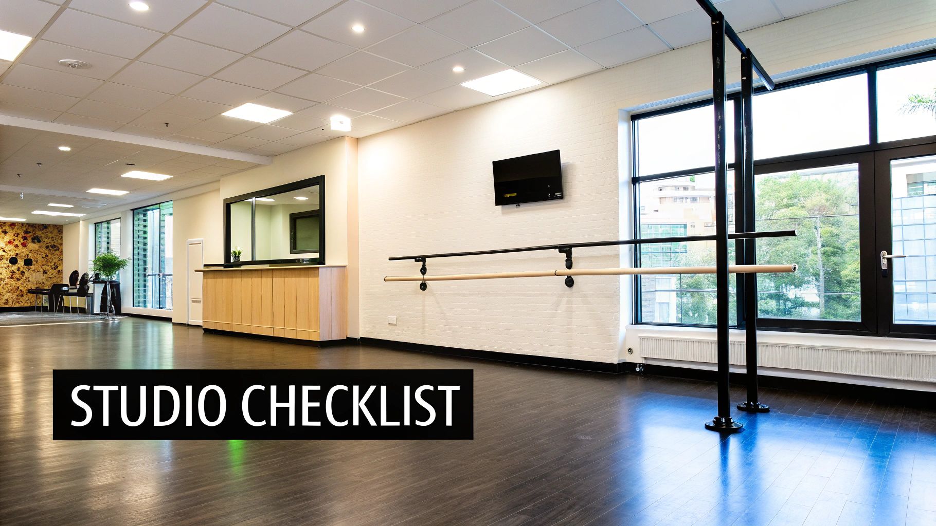 Spacious and modern dance studio with dark wooden floors, ballet barres, and large windows.