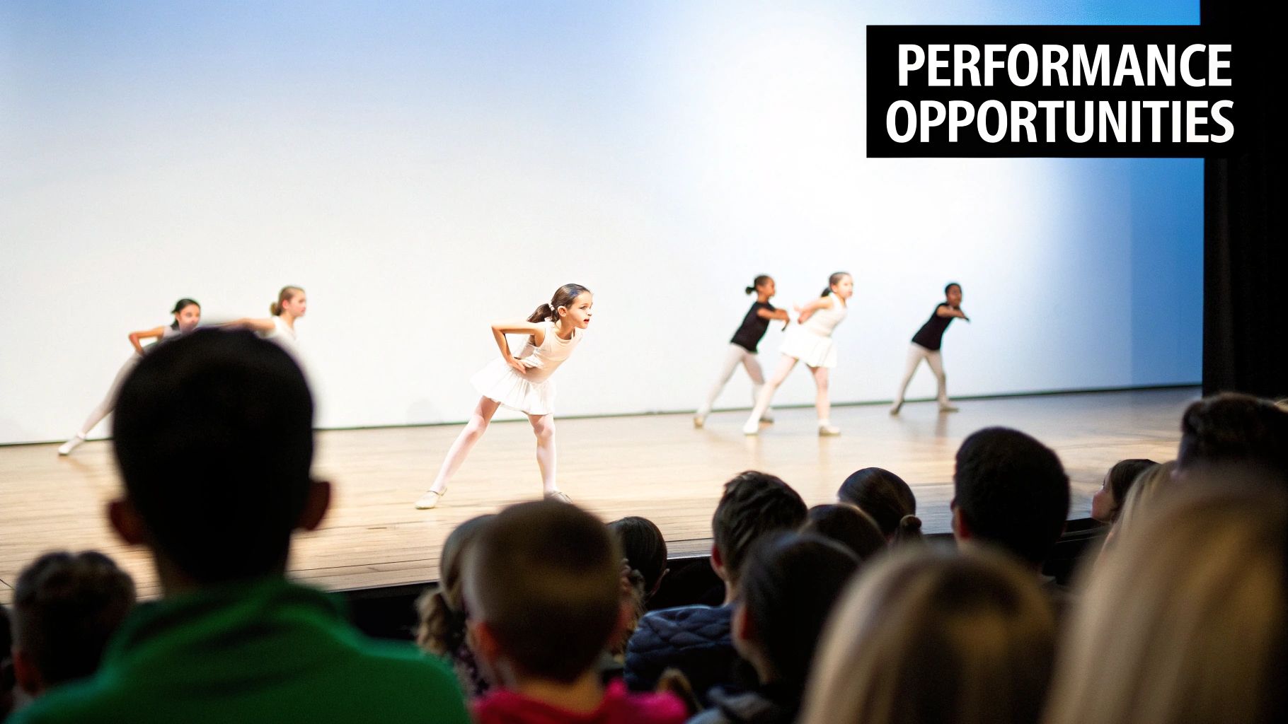 Young girls performing a dance routine on stage for an audience, highlighting performance opportunities.