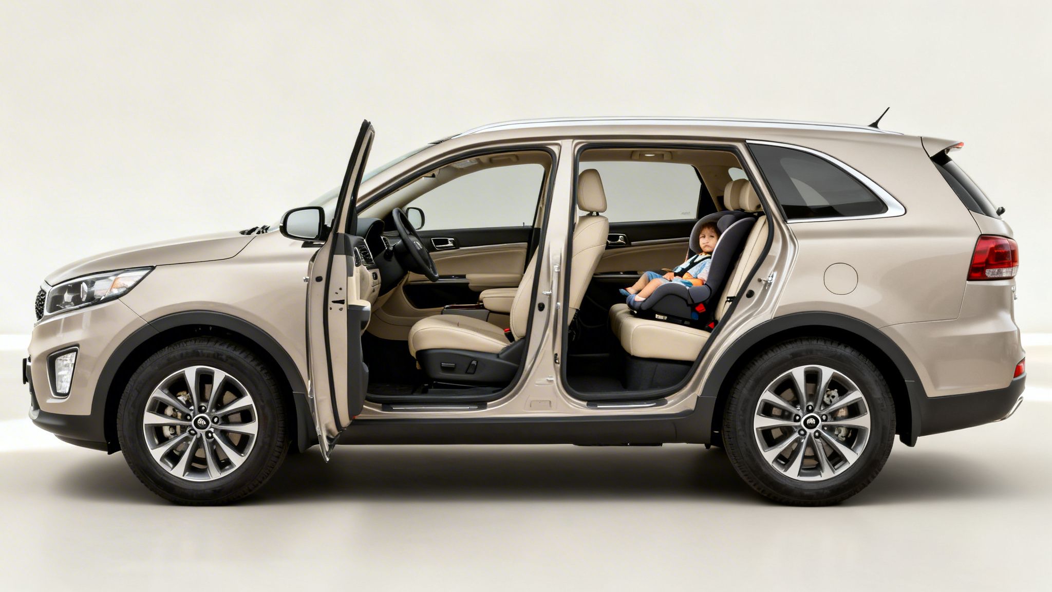 Un SUV Kia Sorento 2017 beige con puertas abiertas y un niño en asiento de seguridad.