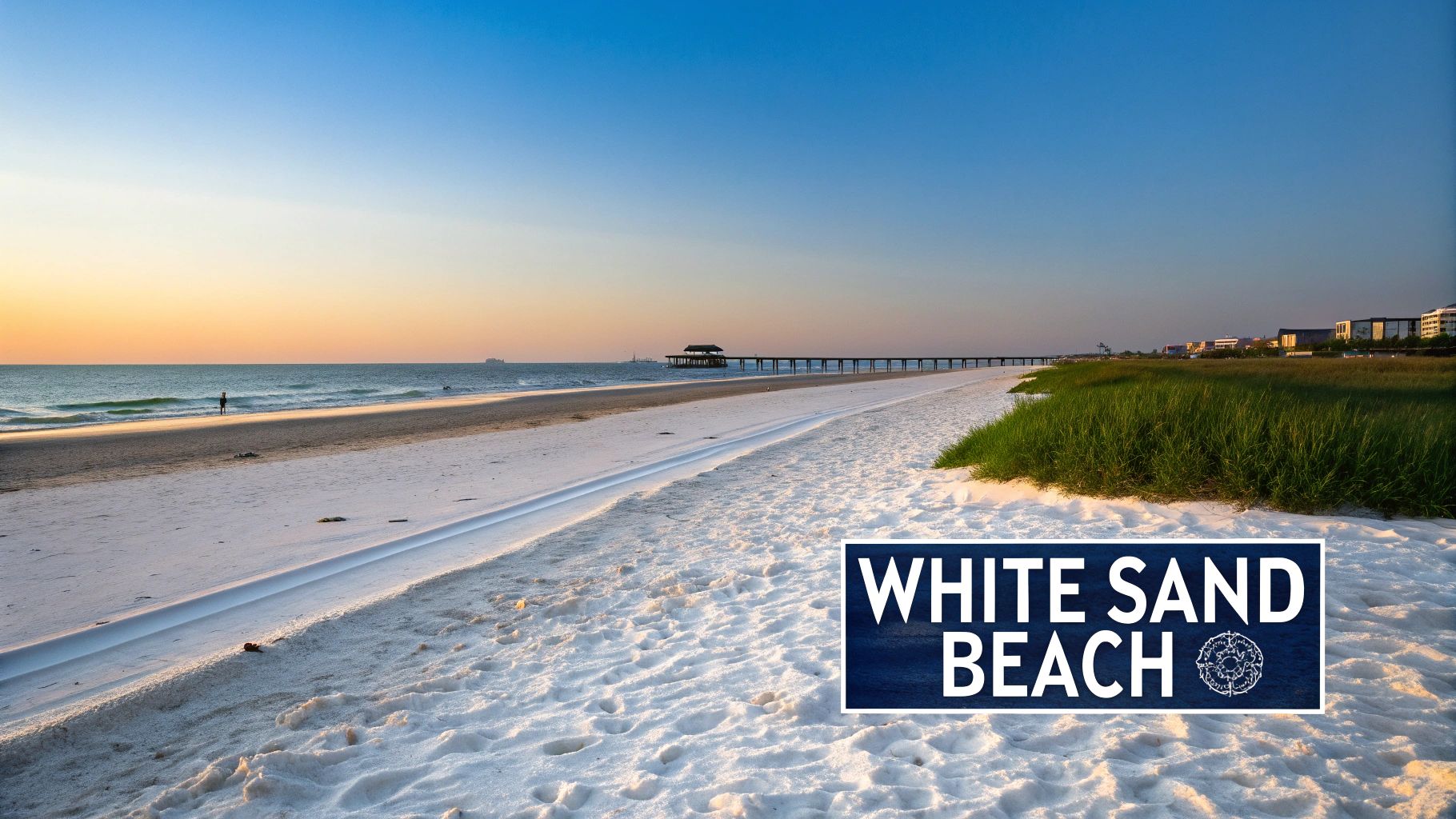 A serene white sand beach at sunset with a long pier, calm ocean, and distant buildings.