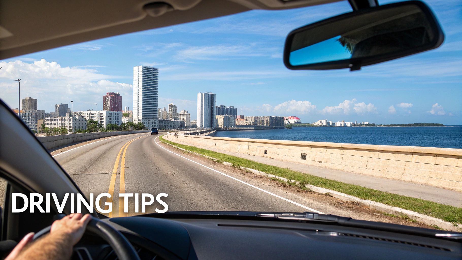 A driver's view from a car on a coastal highway, city skyline, and ocean with 'DRIVING TIPS' text.