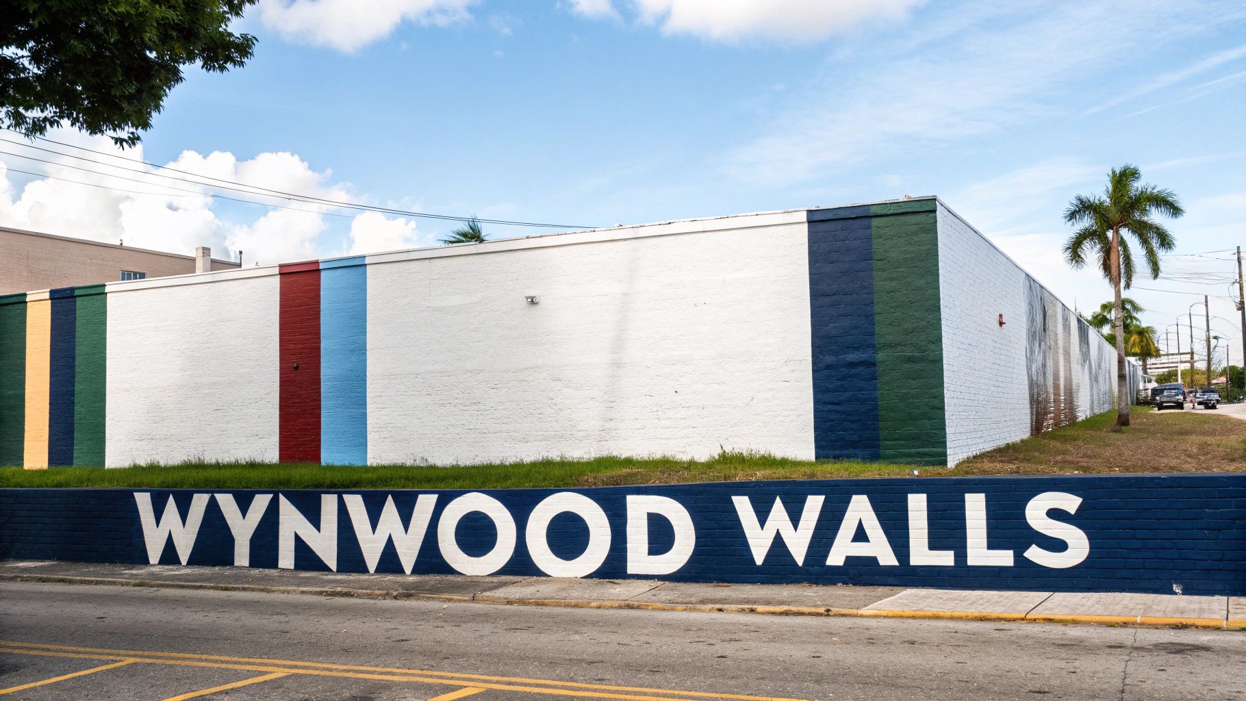 Wynwood Walls street art district with colorful painted wall and blue sign in Miami