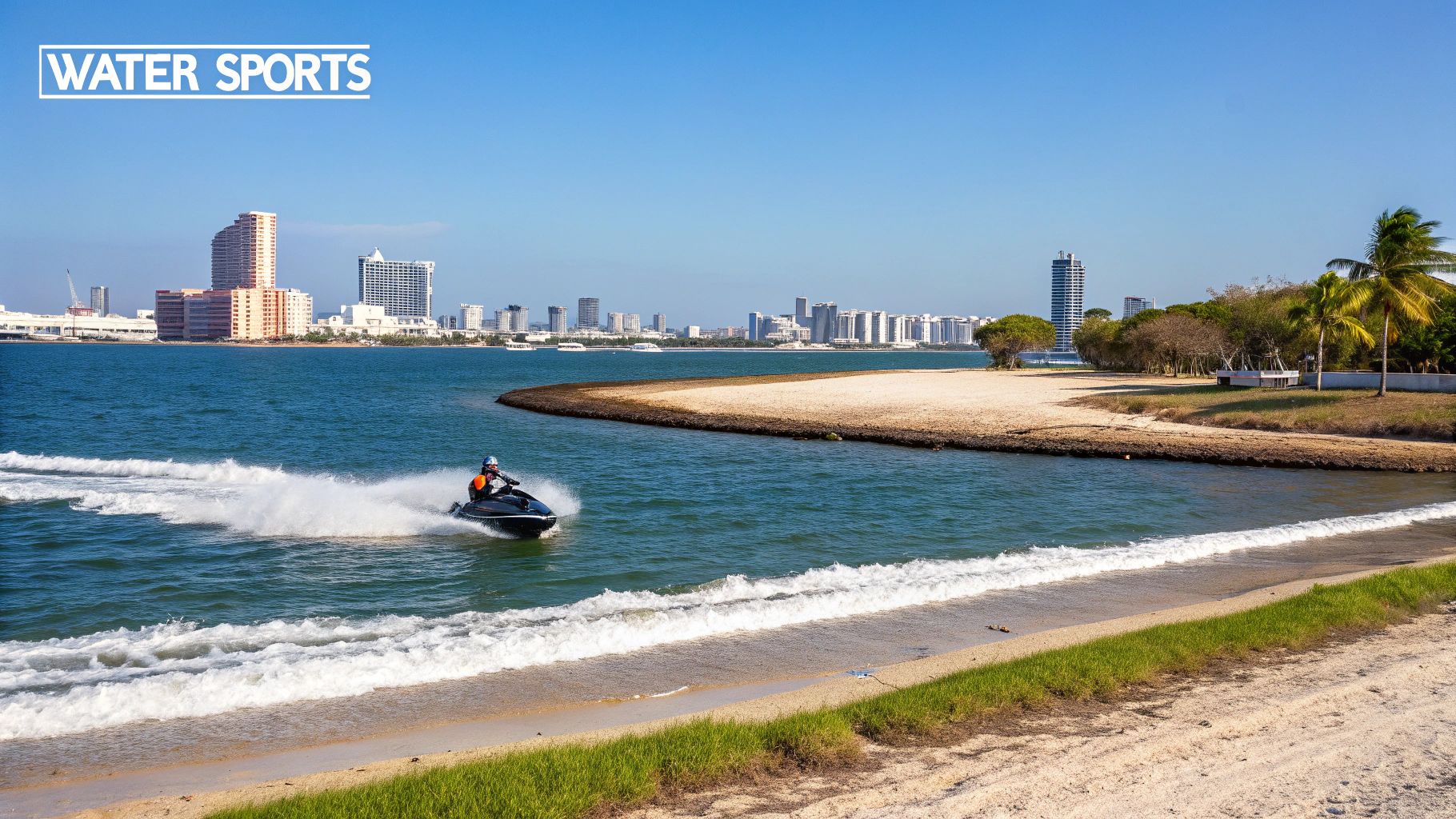 A person speeds on a jet ski across blue water, creating a wake, with a city skyline in the background.