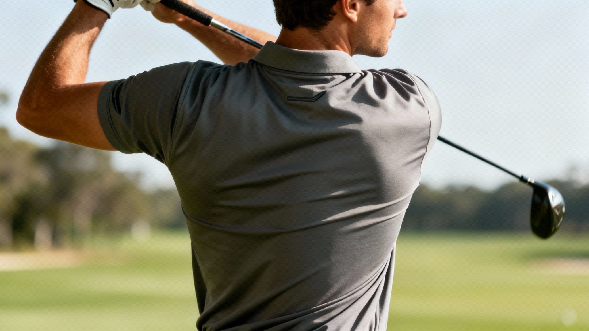 A man in a well-fitting golf shirt ready to swing