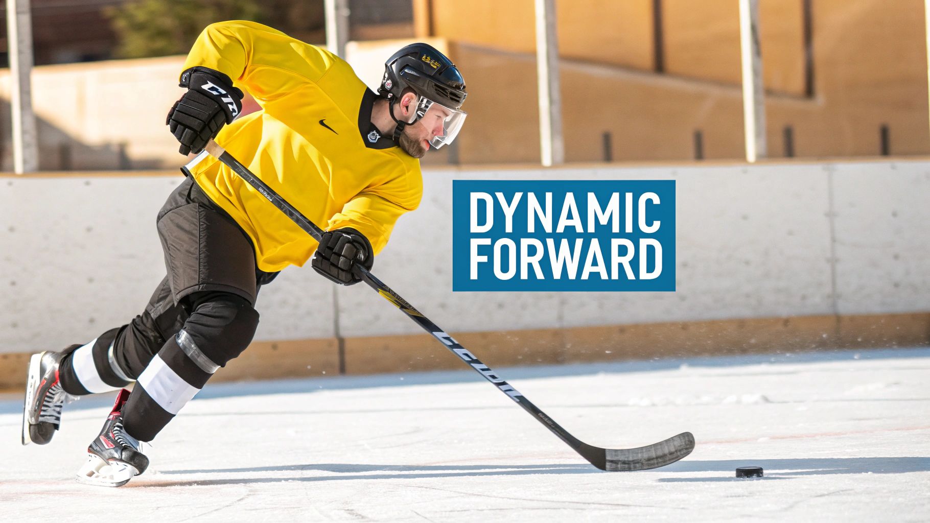 Hockey player in yellow jersey skating with puck during training session on outdoor ice rink