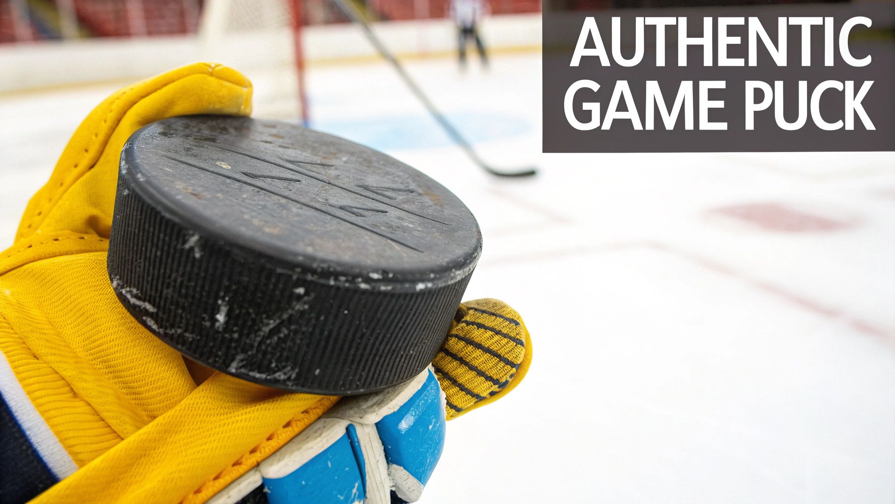 A hand holding up a game-used hockey puck with visible wear and tear.