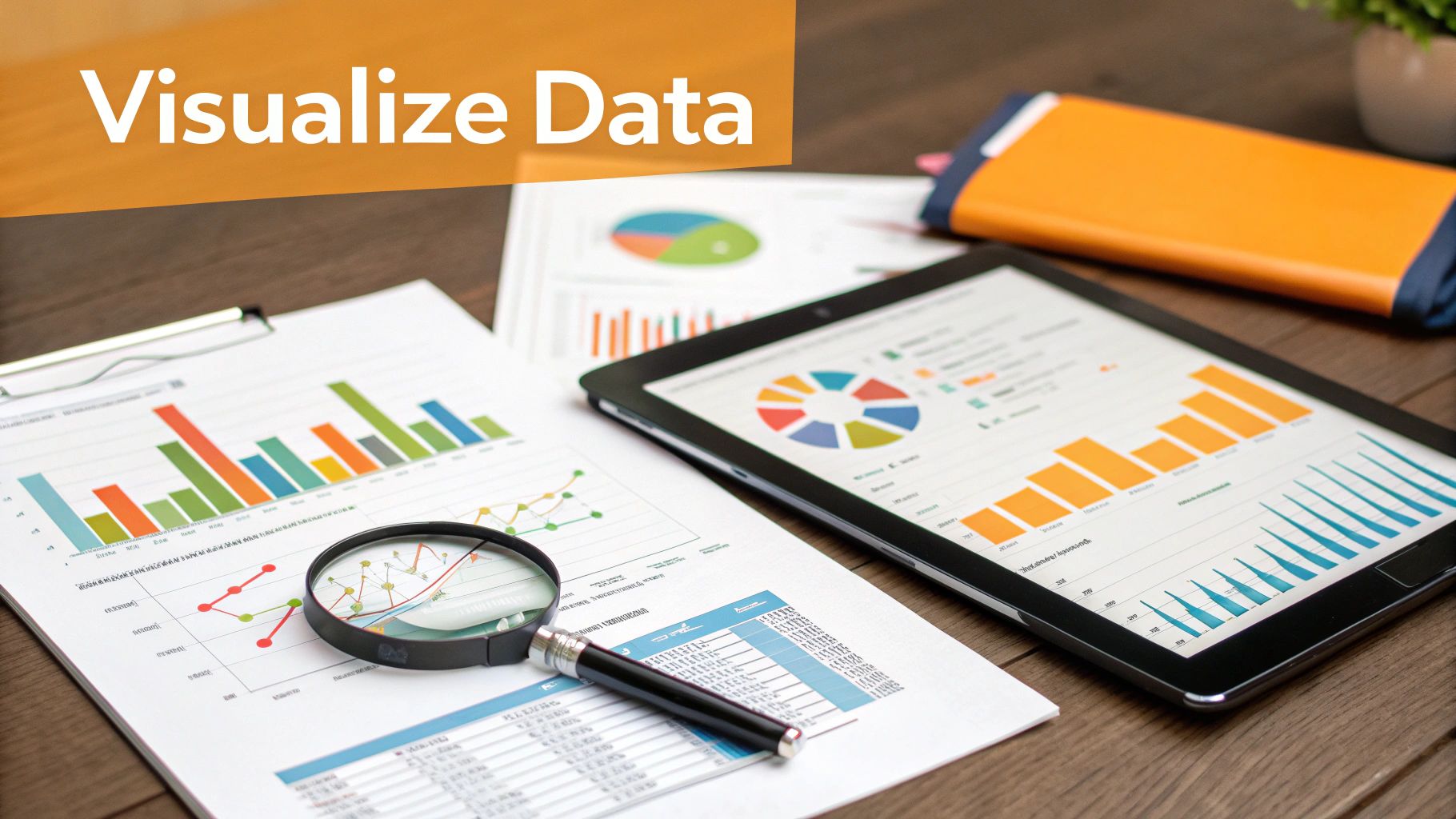 A desk setup featuring data visualization charts, graphs, a tablet, and a magnifying glass.