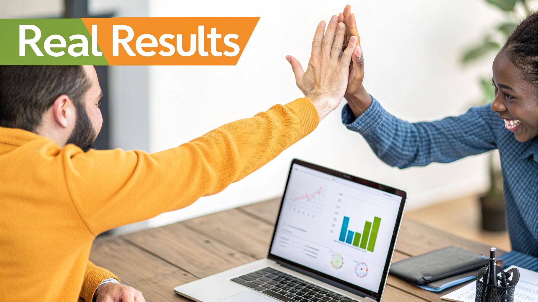 Two diverse professionals high-fiving over a laptop displaying graphs, celebrating real results and teamwork.