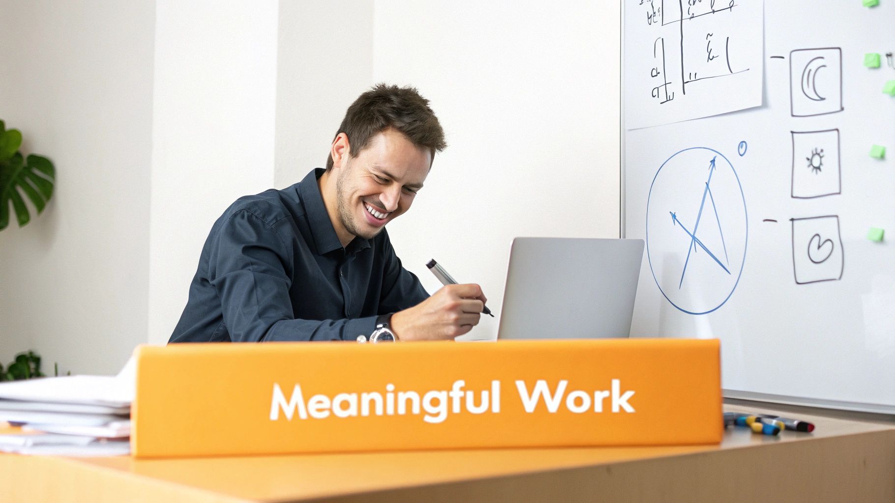 Happy professional man smiling while working on laptop with meaningful work sign on desk