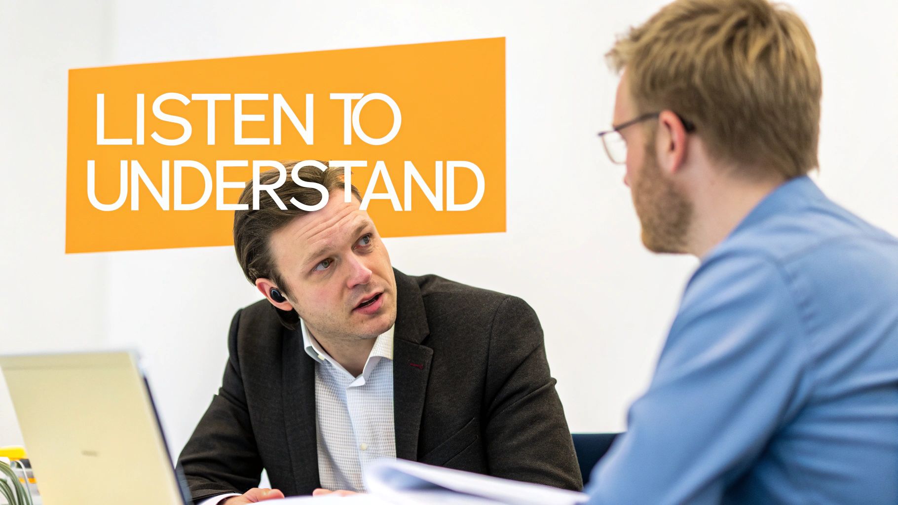 Two professionals engaged in active listening during a workplace discussion meeting