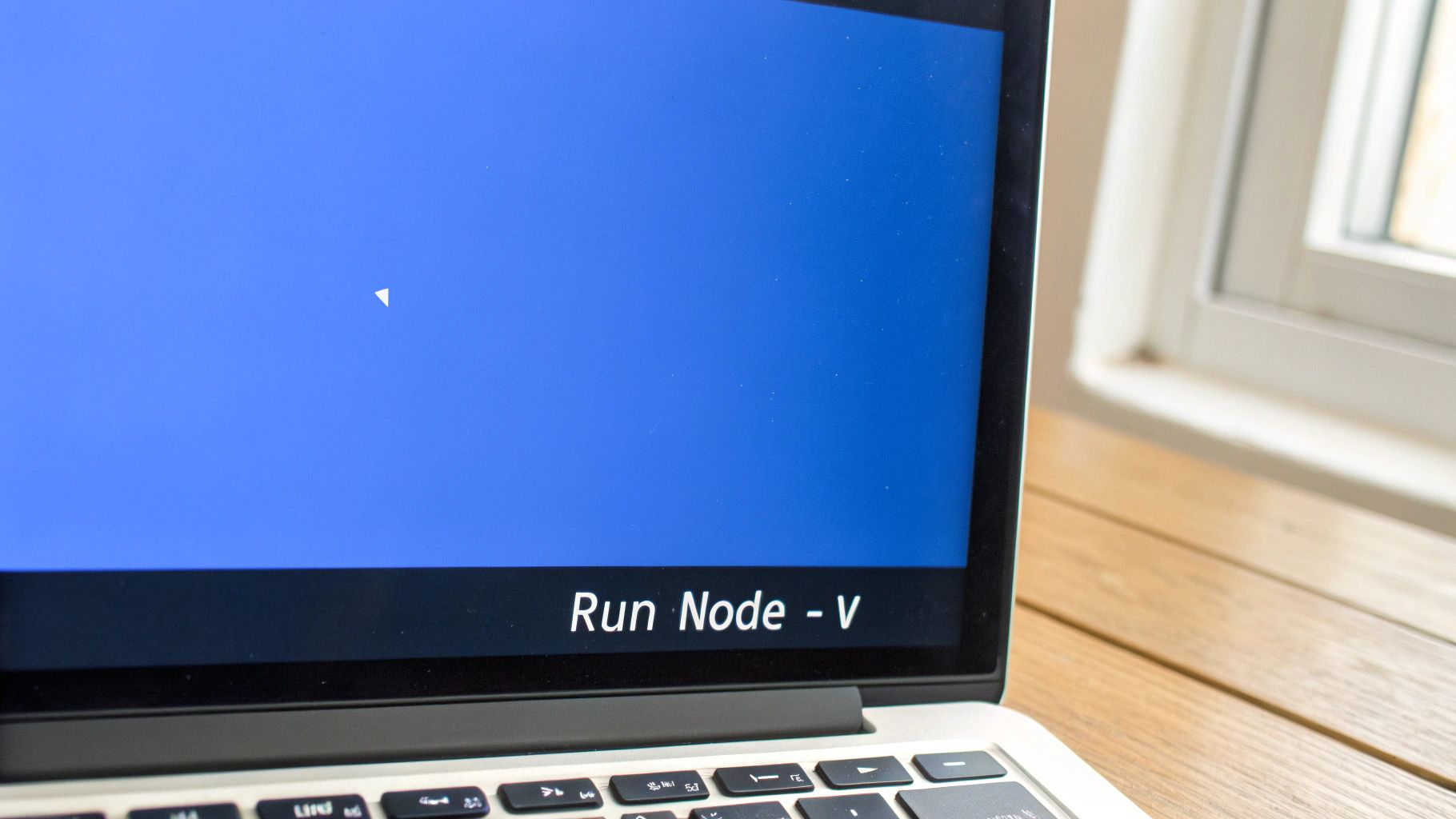 A close-up of a laptop screen displaying the text 'Run Node - V' on a blue background.