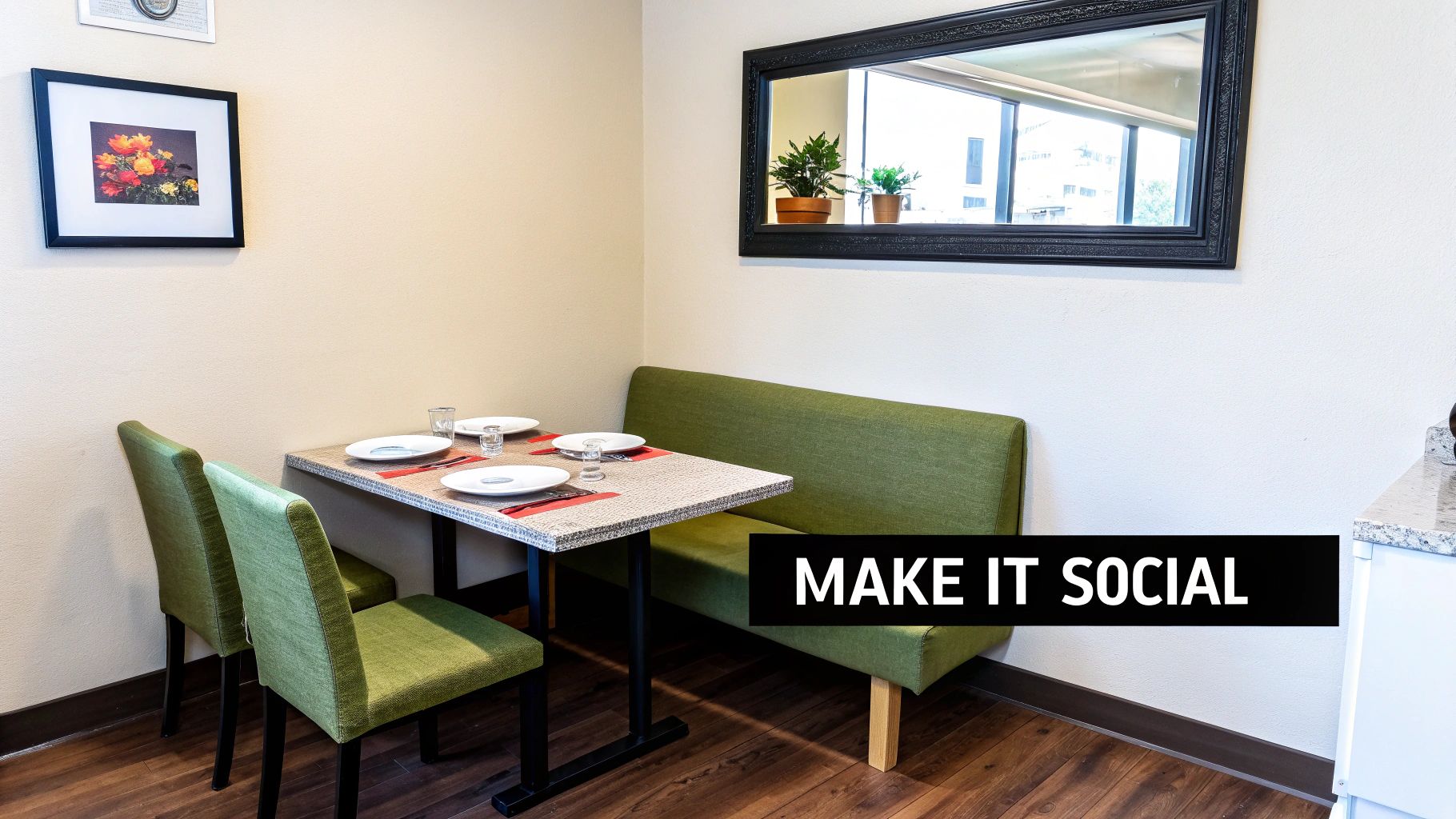 A cozy dining area featuring a small table set for four, green chairs, and a bench, with wall art and a mirror.
