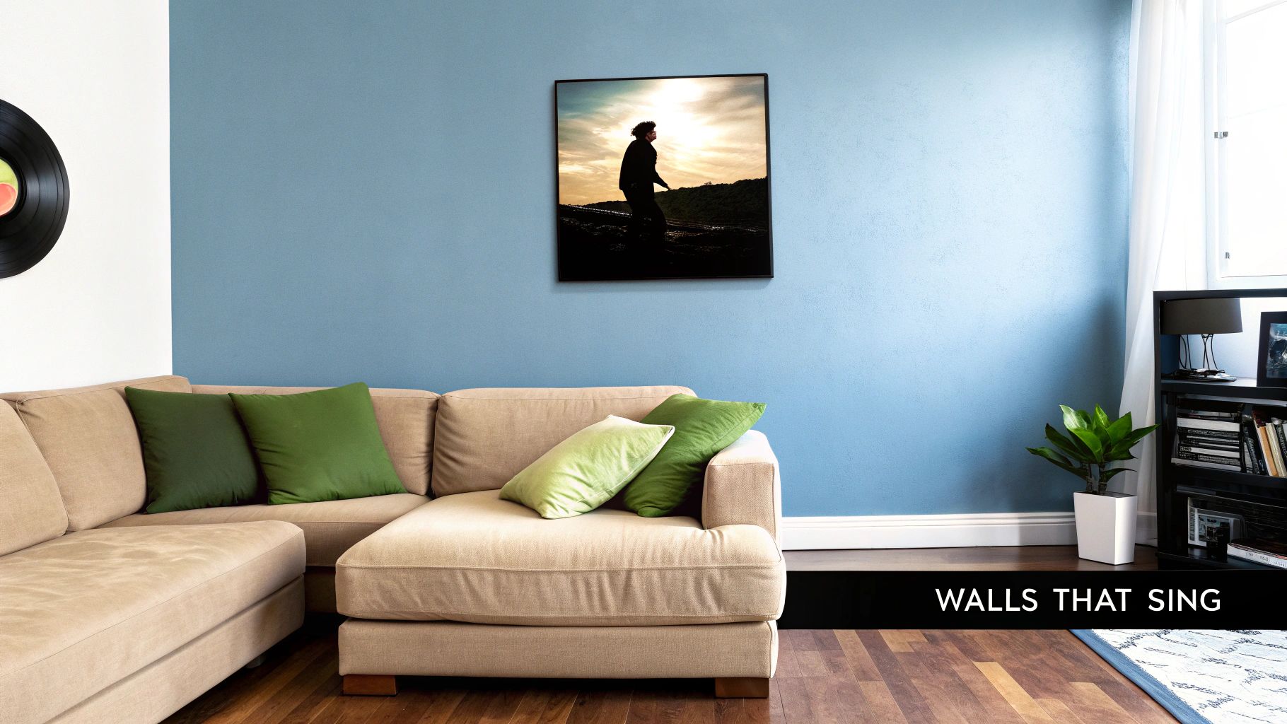 A cozy living room featuring a blue wall, beige sectional sofa, green pillows, and framed artwork.