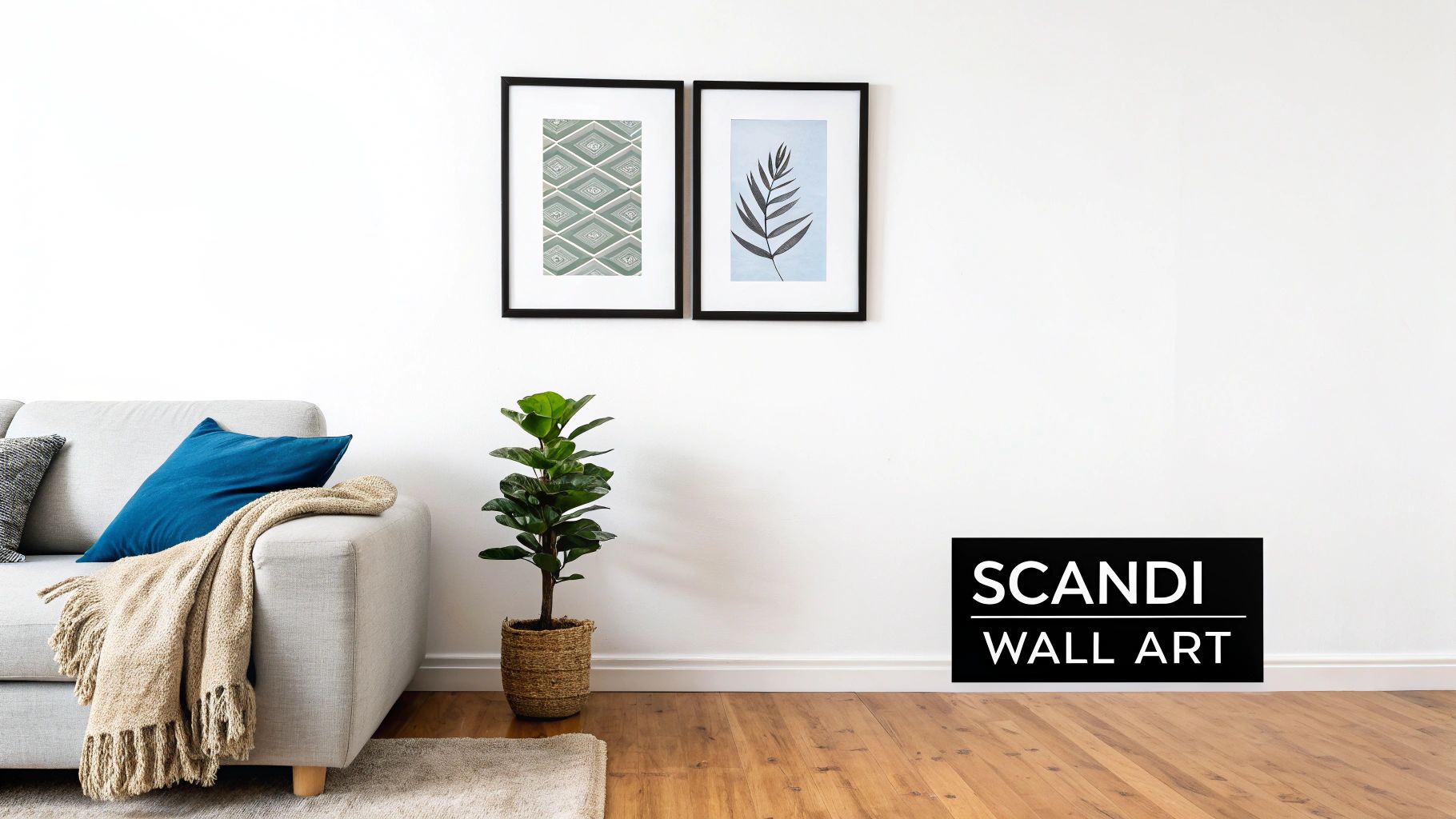 Two framed Scandi wall art prints hang above a modern sofa and fiddle leaf fig plant.