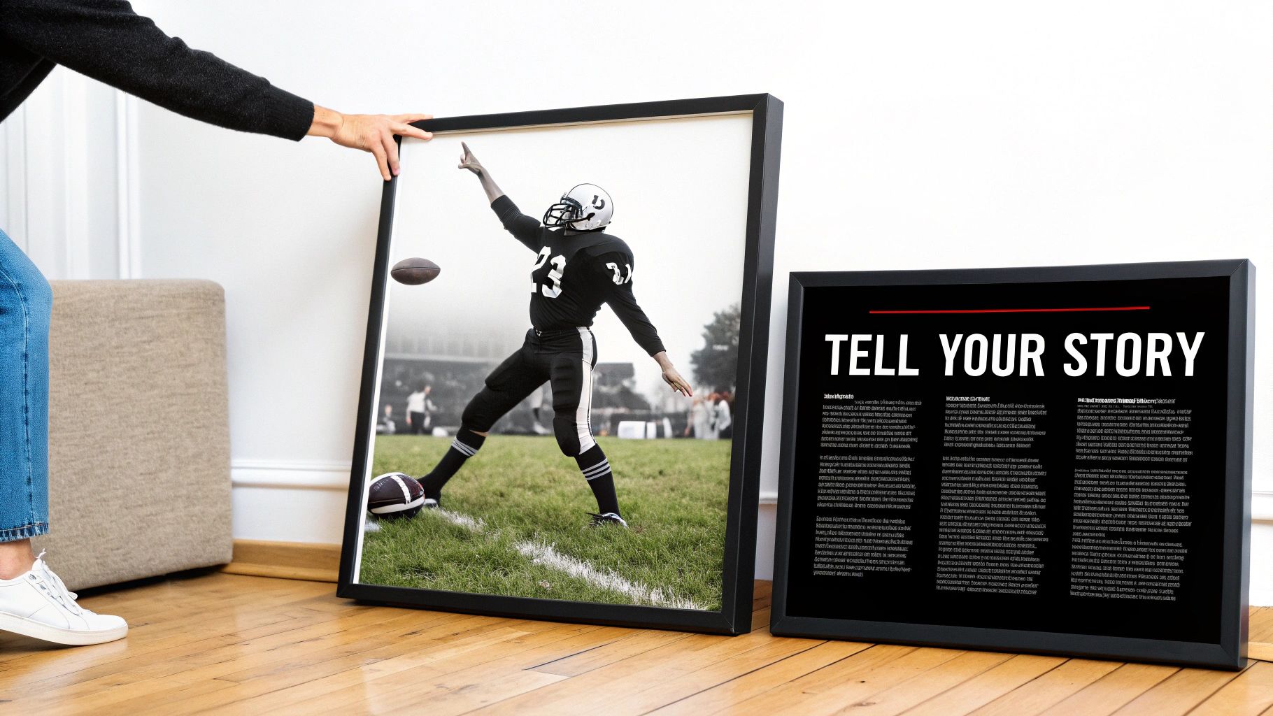 A person adjusting a large framed black and white photo of a football player in action.