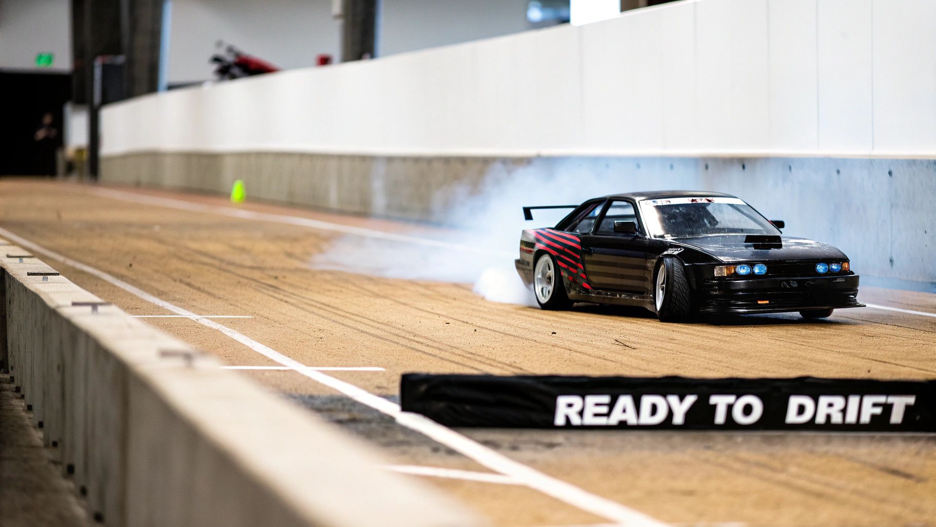 A black 1/10 scale RC drift car drifting with smoke on a track and a 'READY TO DRIFT' sign.