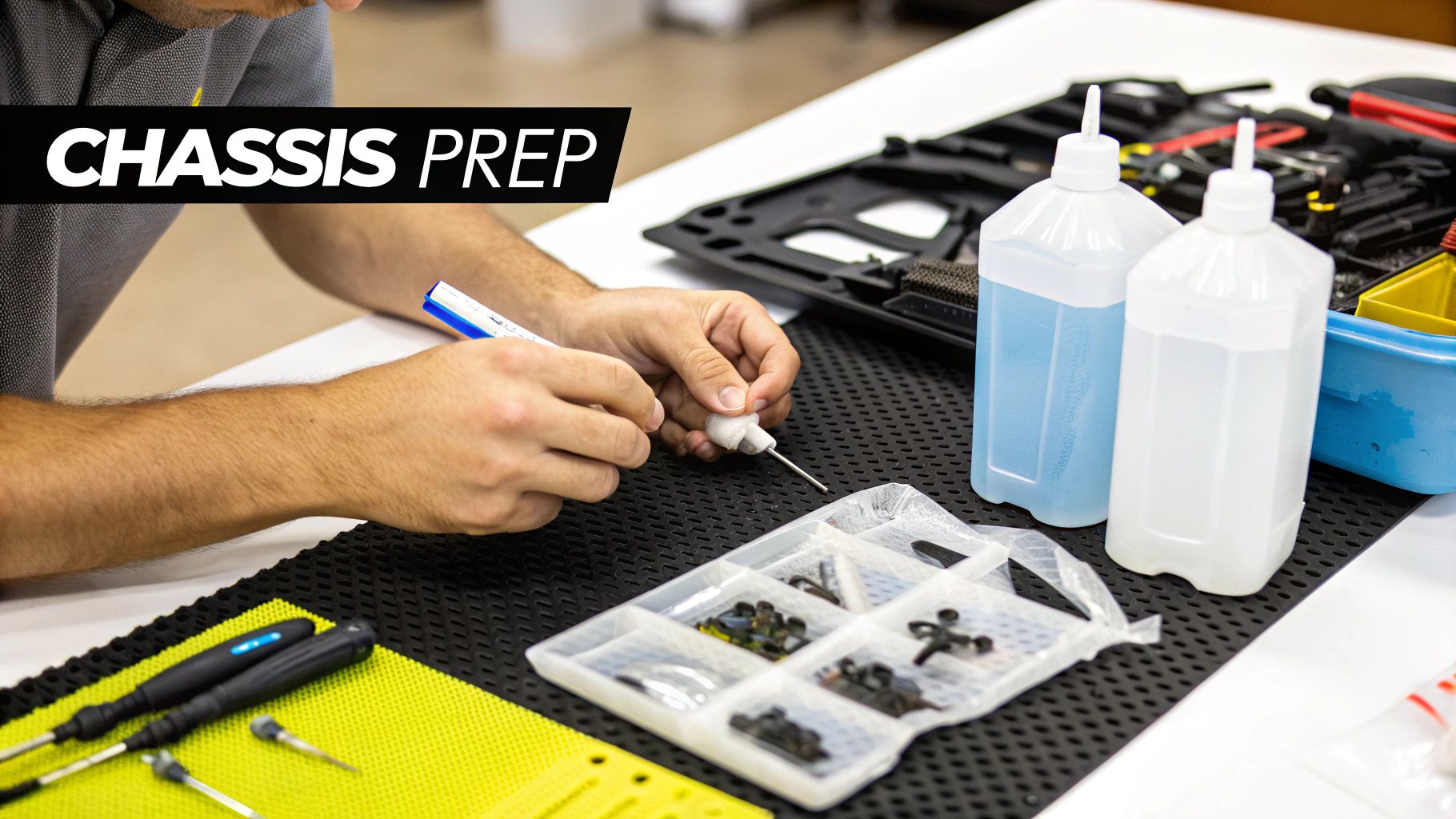 A person's hands meticulously preparing small components for an RC car chassis build on a workbench.