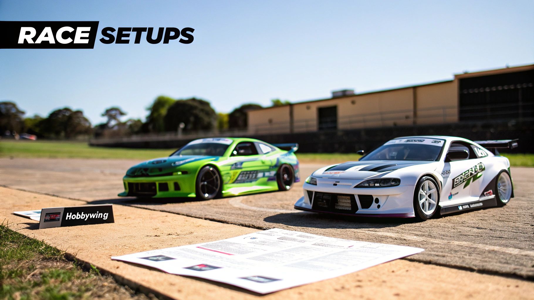 Two detailed remote-controlled drift cars, one green and one white, parked on a concrete surface outdoors with a Hobbywing sign.