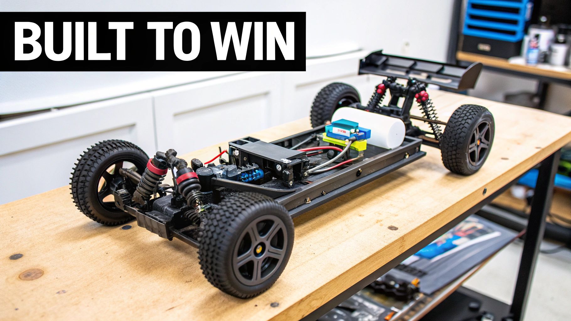 A custom-built remote control car with a spoiler and visible electronics sits on a wooden workbench.
