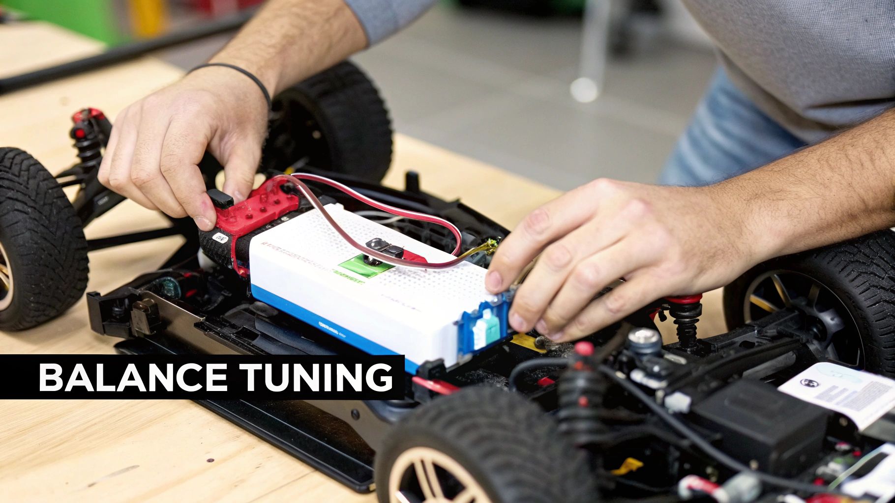 Close-up of hands working on the internal electronics of a remote control car, connecting wires to a battery.