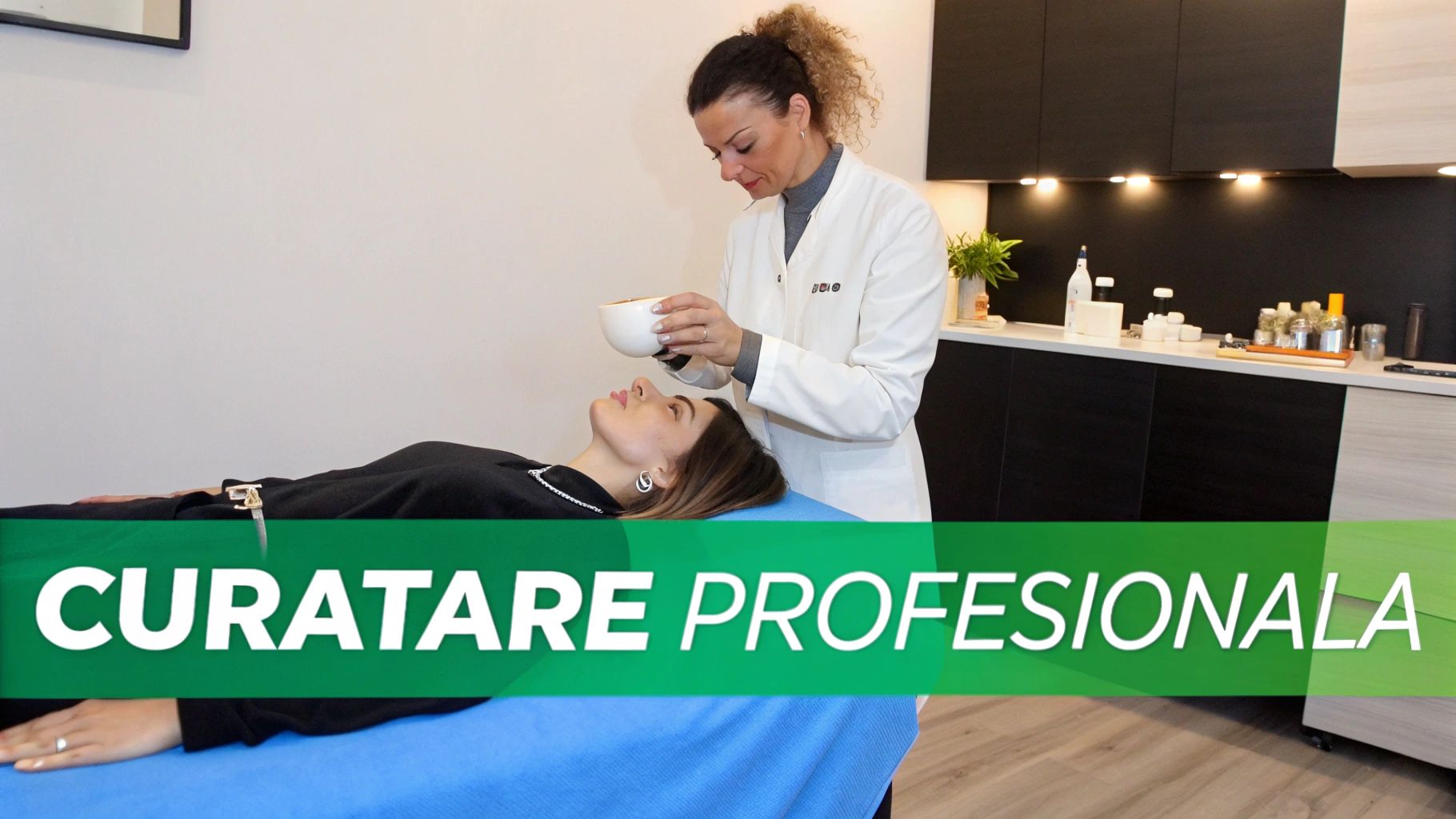 O femeie primește un tratament facial profesional de la o specialistă, pe o masă de tratament.