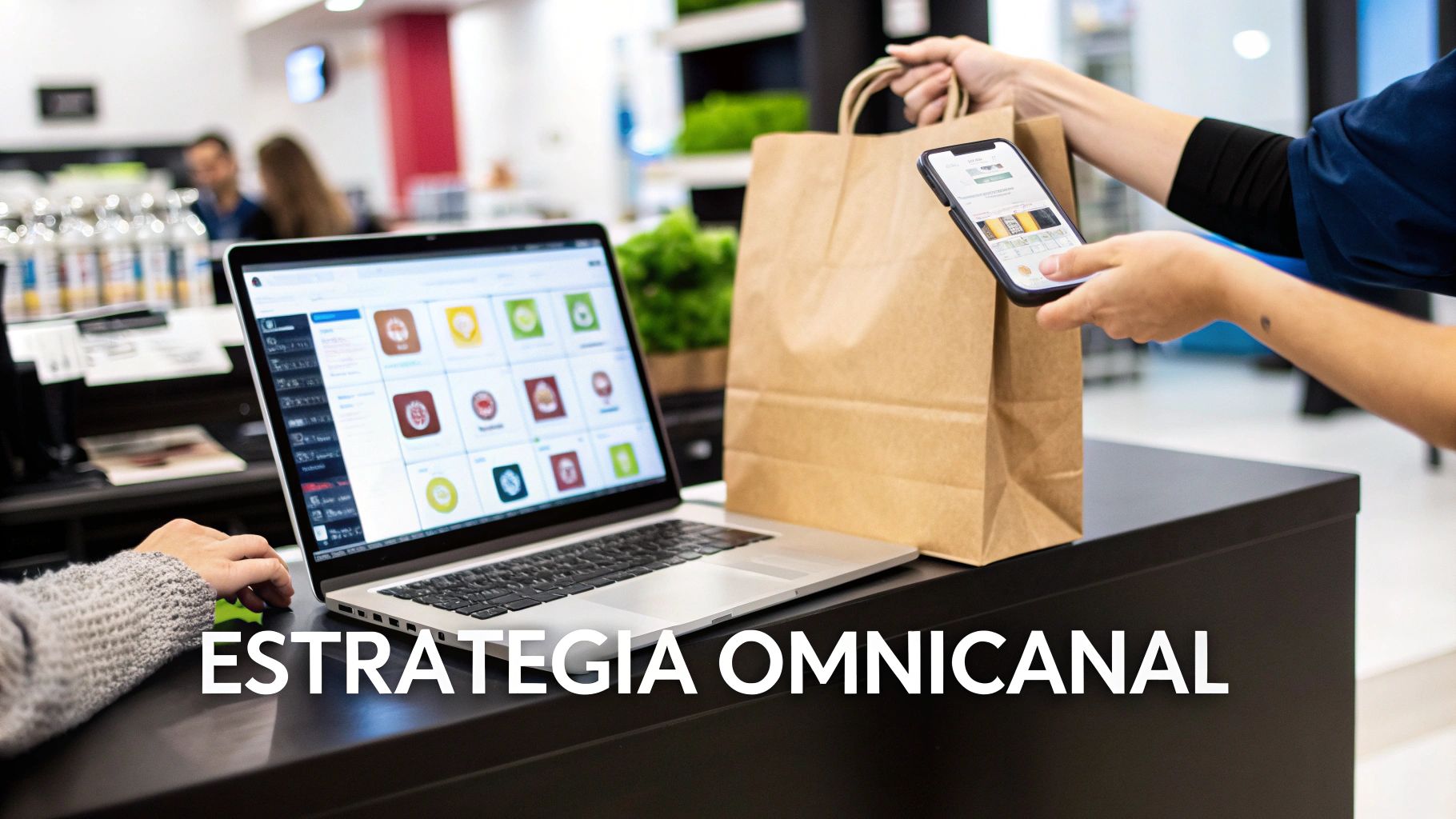 Persona usando laptop y smartphone en un entorno comercial, representando una estrategia omnicanal de ventas.