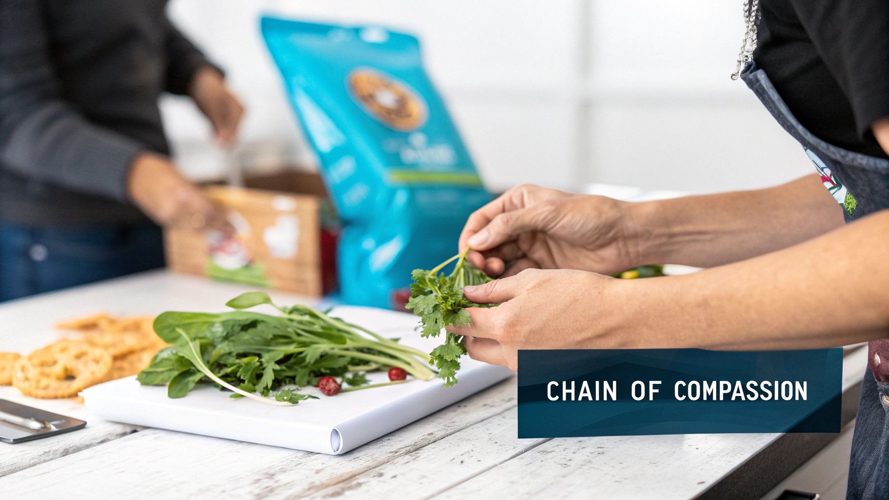 Hands preparing fresh herbs and greens on a cutting board, with another person packing items.